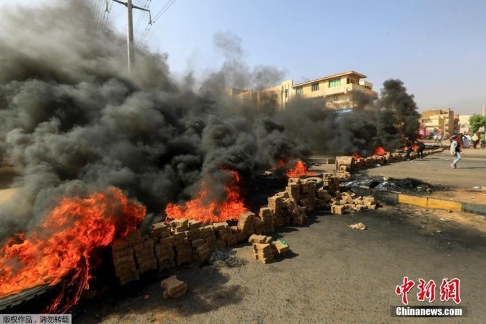 當(dāng)?shù)貢r(shí)間10月25日，蘇丹局勢(shì)發(fā)生突變，過(guò)渡政府總理被“綁架”，政府部長(zhǎng)被軍方抓捕，國(guó)家進(jìn)入緊急狀態(tài)，大量民眾走上街頭對(duì)軍方行動(dòng)進(jìn)行抗議，已有7人在抗議活動(dòng)中死亡，140人受傷。圖為抗議活動(dòng)中燃燒的輪胎。