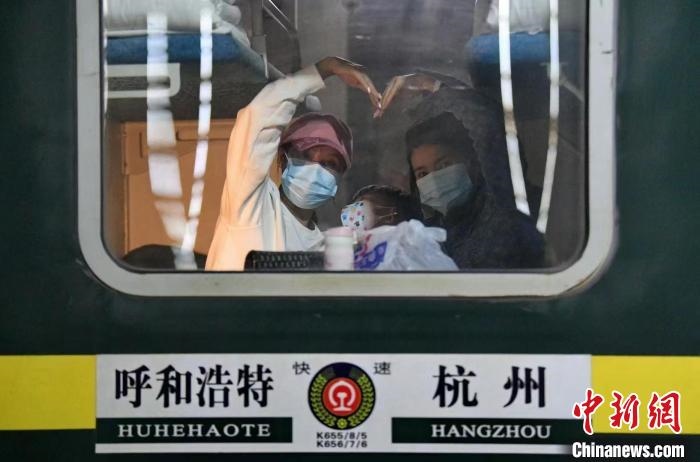 圖為登上轉(zhuǎn)運(yùn)火車的游客向額濟(jì)納比心。　王磊 攝