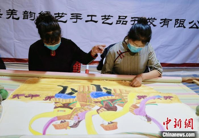 圖為皮繡藝人在市集上“秀”指尖技藝?！●R銘言 攝