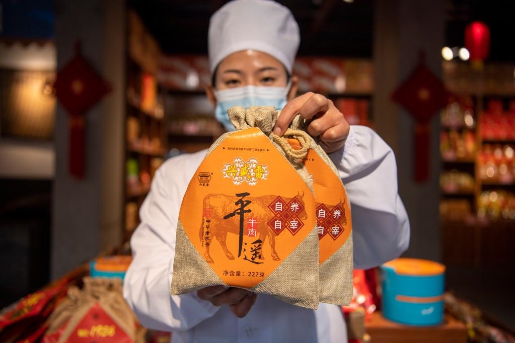 1月27日，在平遙古城南大街的一家平遙牛肉店內(nèi)，工作人員展示一款牛肉產(chǎn)品。新華社記者 楊晨光 攝