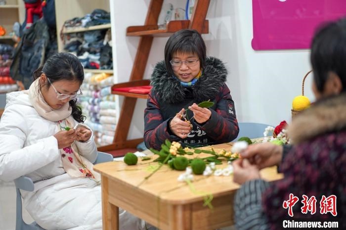 文創(chuàng)工作室的姐妹們正在鉤織月桂葉片。　古良駒 攝