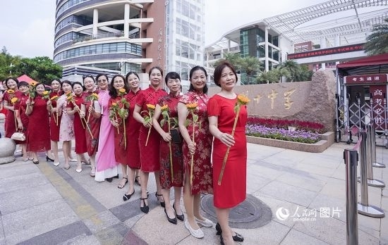 6月7日一早，廈門雙十中學(xué)考生家長們身穿旗袍，手拿向日葵在考場外為孩子加油打氣，寓意“旗開得勝，一舉奪魁”。人民網(wǎng)記者 陳博攝
