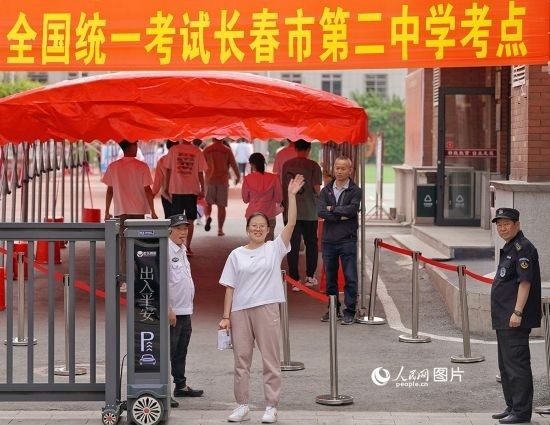 6月7日，在長春市第二中學(xué)考點(diǎn)，一名考生信心滿滿進(jìn)入考場，并與家長揮手致意。人民網(wǎng)記者 李洋攝