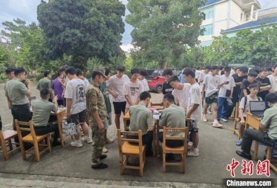 專武干部在發(fā)放兵役登記證。韋碩 攝