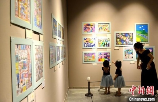 圖為家長帶著孩子參觀展覽。呂明 攝