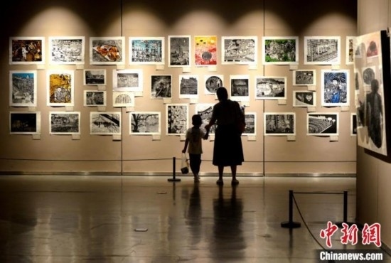 圖為家長帶著孩子參觀展覽。呂明 攝