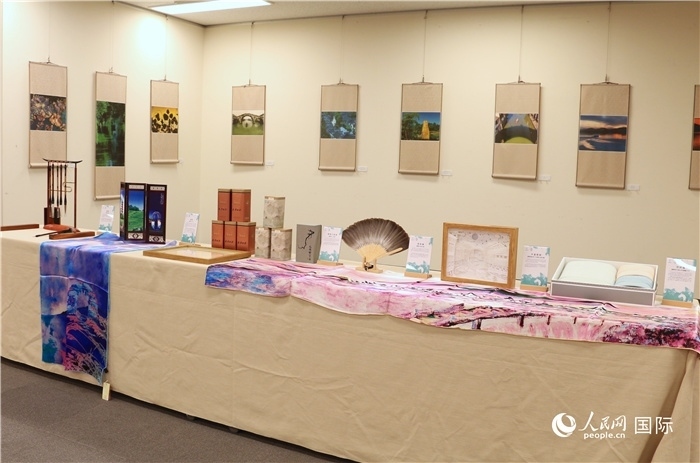 現(xiàn)場展出的馮學敏攝影作品與湖州市特色工藝品。（人民網(wǎng) 許可攝）