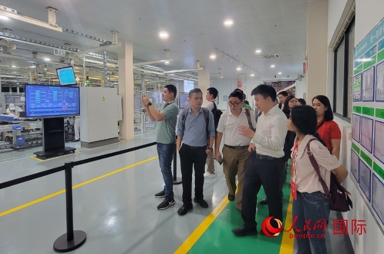 廣汽埃安工作人員向外媒記者進(jìn)行介紹。人民網(wǎng) 寧玉瑛攝