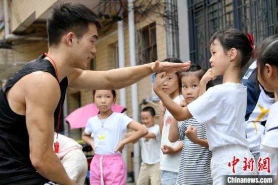 圖為大學(xué)生志愿者在組織孩子們參加體育健身活動(dòng)。廖光福 攝