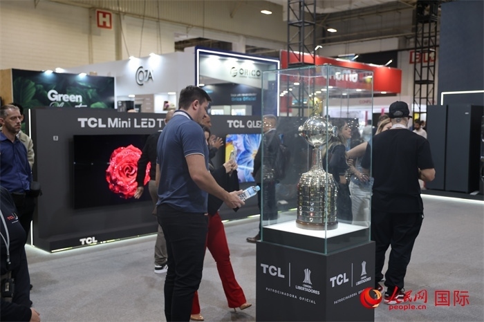 參觀者在TCL展臺前觀看南美解放者杯獎杯，據(jù)介紹，TCL是南美解放者杯（2023—2026賽季）全球官方合作伙伴。（人民網(wǎng)記者 時元皓攝）