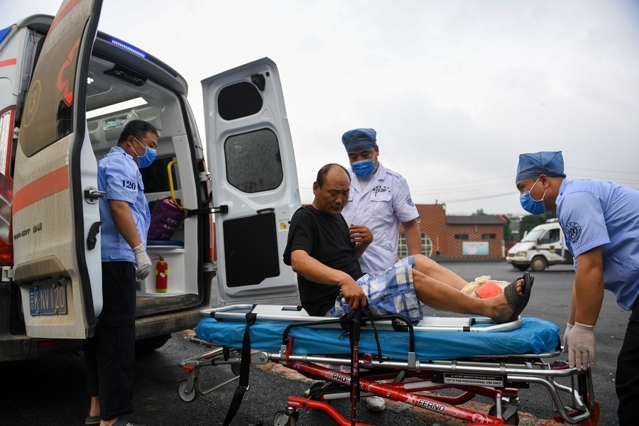 8月1日，在北京市門(mén)頭溝區(qū)妙峰山鎮(zhèn)妙峰山民族學(xué)校臨時(shí)安置點(diǎn)，北京急救中心工作人員在轉(zhuǎn)運(yùn)一名受傷村民。新華社記者 鞠煥宗 攝