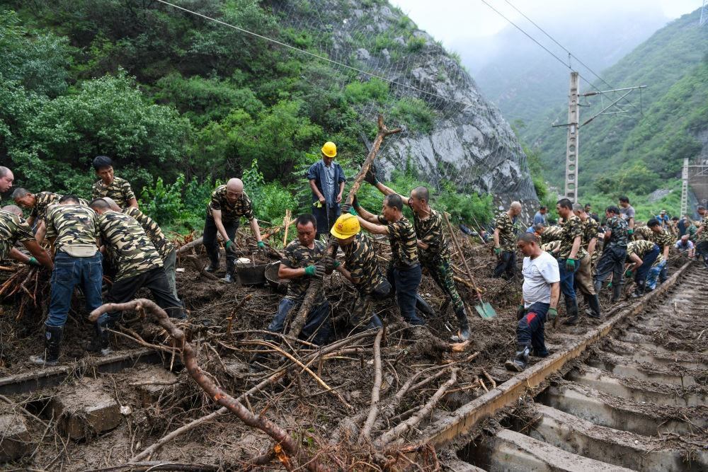8月1日，在北京市門頭溝區(qū)水峪嘴村附近一段被阻斷的鐵路線上，中鐵六局工作人員在清理軌道上的雜物，全力恢復(fù)交通。新華社記者 鞠煥宗 攝