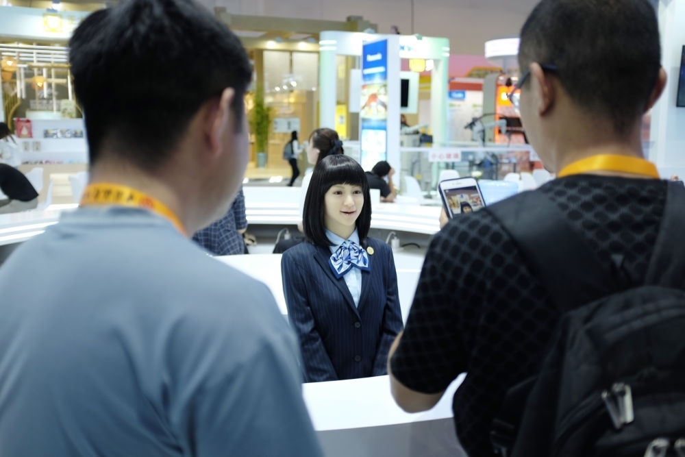 9月1日，媒體記者在國家會議中心與服務(wù)機器人互動。新華社記者 劉夢琪 攝