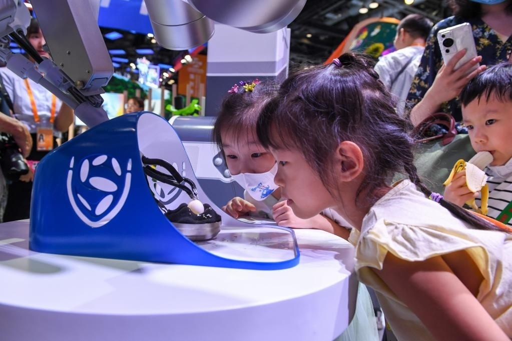 9月3日，幾名小朋友在國家會(huì)議中心觀看單孔腔鏡手術(shù)機(jī)器人展示。新華社記者 鞠煥宗 攝