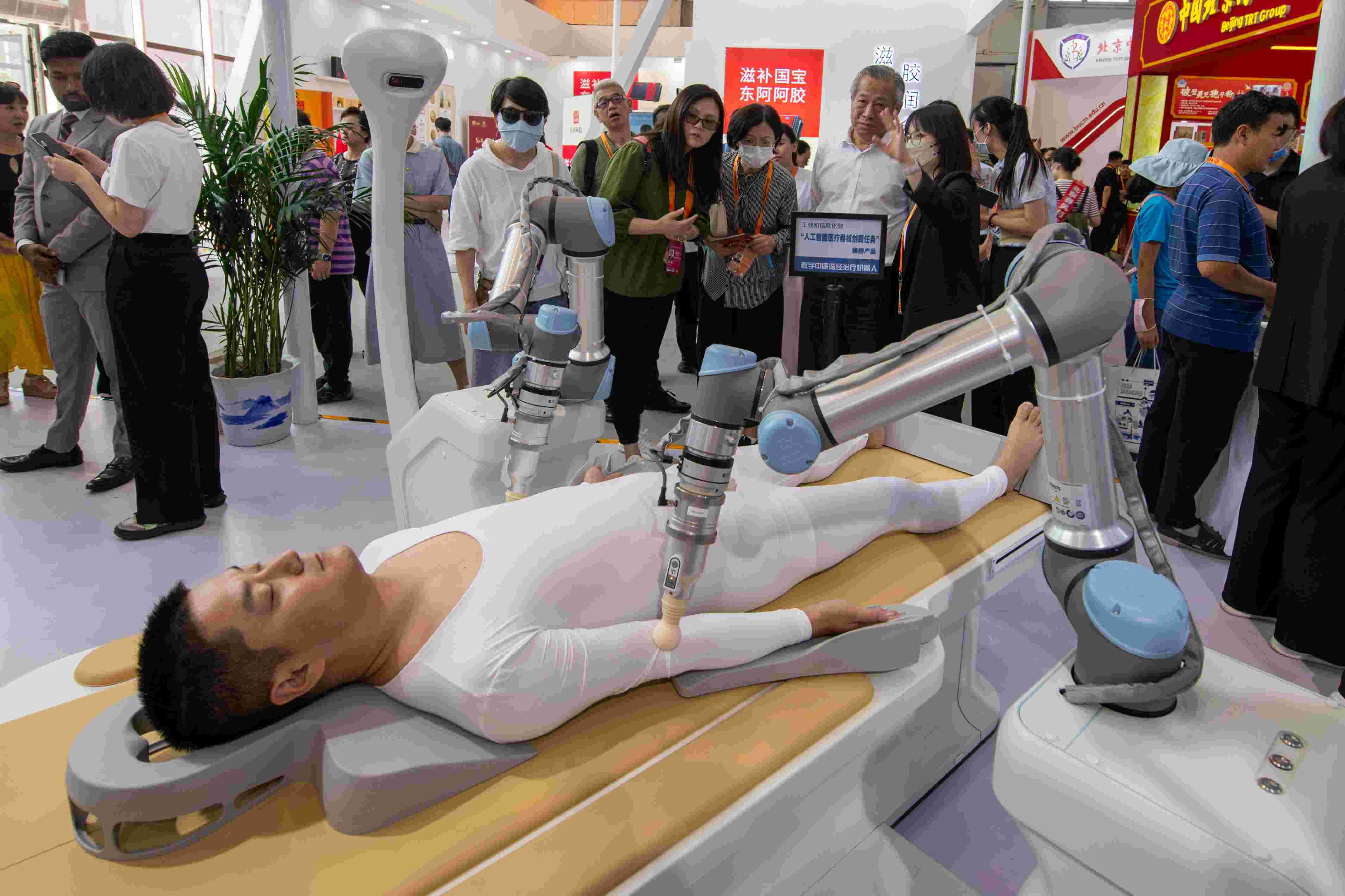 在位于首鋼園的健康衛(wèi)生服務(wù)展區(qū)，觀眾正在參觀數(shù)字中醫(yī)循經(jīng)治療機器人。人民網(wǎng)記者 翁奇羽攝