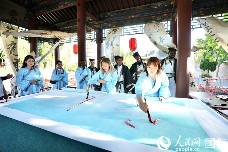 選手們提筆書(shū)寫(xiě)“家園”二字。人民網(wǎng) 盧鵬宇攝