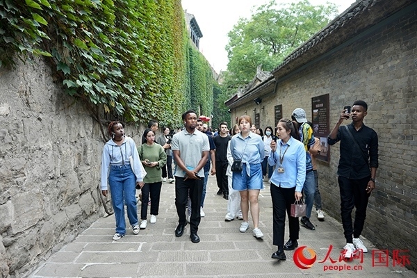 選手們認(rèn)真聆聽導(dǎo)游講解。人民網(wǎng) 盧鵬宇攝