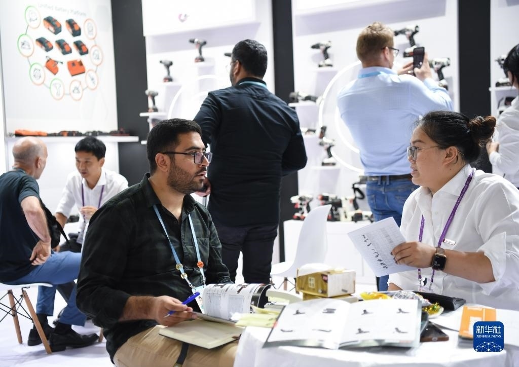 10月15日，在一家電動(dòng)工具展臺(tái)，外國采購商在洽談業(yè)務(wù)。新華社記者 鄧華 攝