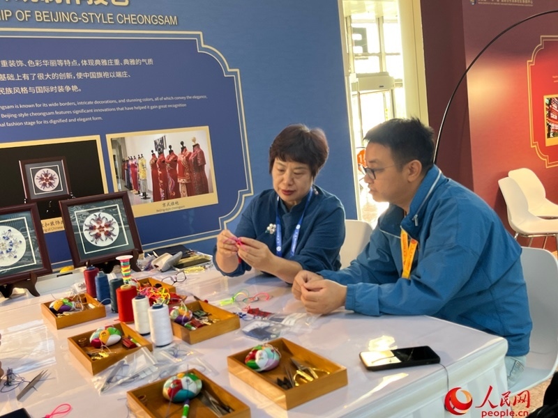 記者在新聞中心非遺傳承人展區(qū)進(jìn)行體驗(yàn)。人民網(wǎng)記者 杜燕飛攝