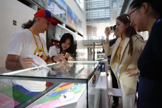 10月16日，參會記者在“一帶一路”國際合作高峰論壇新聞中心參觀展示的中國非物質文化遺產展品。新華社記者 陳斌 攝