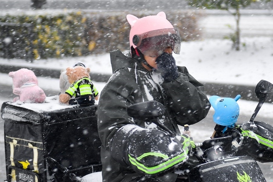 11月6日，在長春市街頭，一名外賣員在雪中騎行。新華社記者 許暢 攝