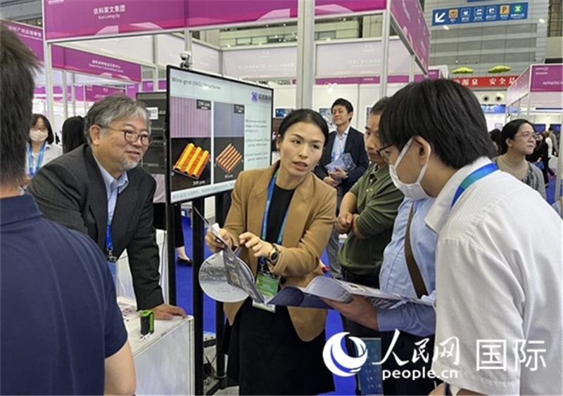 工作人員向參觀者介紹超級(jí)噴墨技術(shù)。（人民網(wǎng)記者 陳思攝）