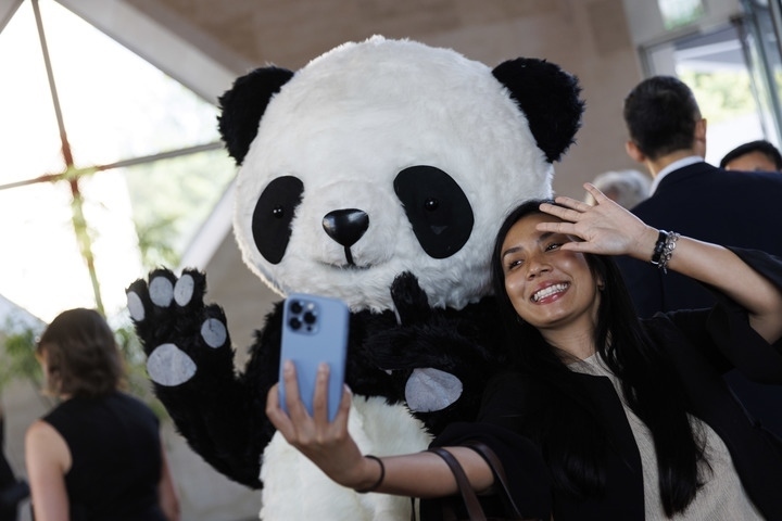 2022年8月24日，在美國(guó)華盛頓中國(guó)駐美國(guó)大使館，來(lái)賓與大熊貓玩偶合影。