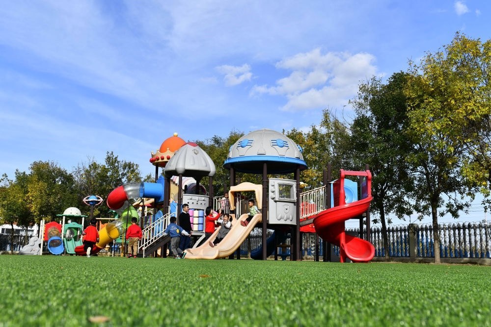 在山東省東營市墾利區(qū)楊廟社區(qū)幼兒園，孩子們在老師的帶領下進行戶外活動（2021年10月19日攝）。新華社記者 郭緒雷 攝