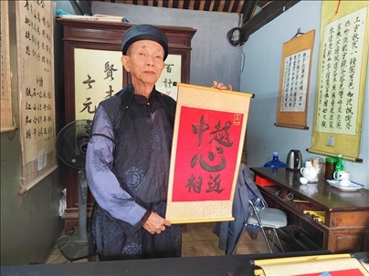 越南首都河內(nèi)文廟內(nèi)，阮明珠展示“中越心相近”書(shū)法作品。