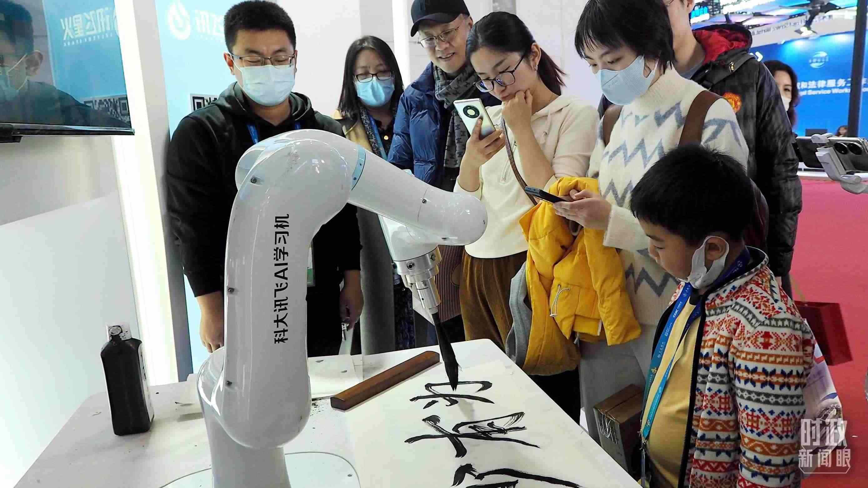 △觀眾在首屆鏈博會上體驗(yàn)AI書法機(jī)器人。
