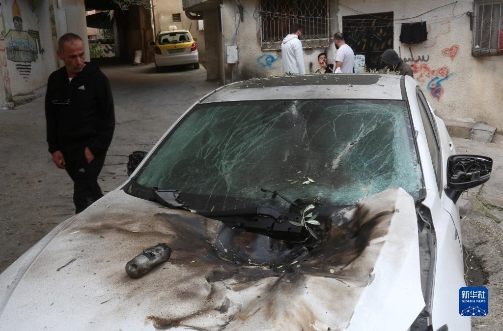 12月17日，在約旦河西岸城市圖勒凱爾姆附近的一處難民營(yíng)，人們查看在沖突中損毀的車輛。新華社發(fā)（尼達(dá)爾·艾仕塔耶?dāng)z）
