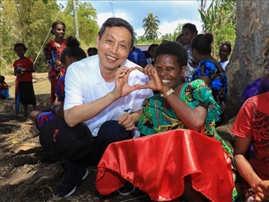 2023年12月18日，中國駐瓦努阿圖大使李名剛和前來觀看瓦努阿圖公路項目二期馬勒庫拉段移交儀式的當?shù)鼐用窈嫌?。人民網(wǎng) 賀吉攝