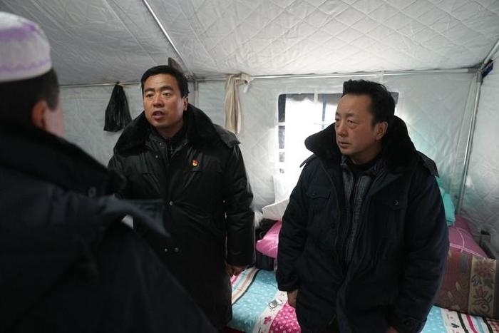 2023年12月22日，積石山縣大河家鎮(zhèn)大河村黨支部書記馬成忠（右二）在帳篷里和受災(zāi)群眾交流。新華社記者 陳斌 攝