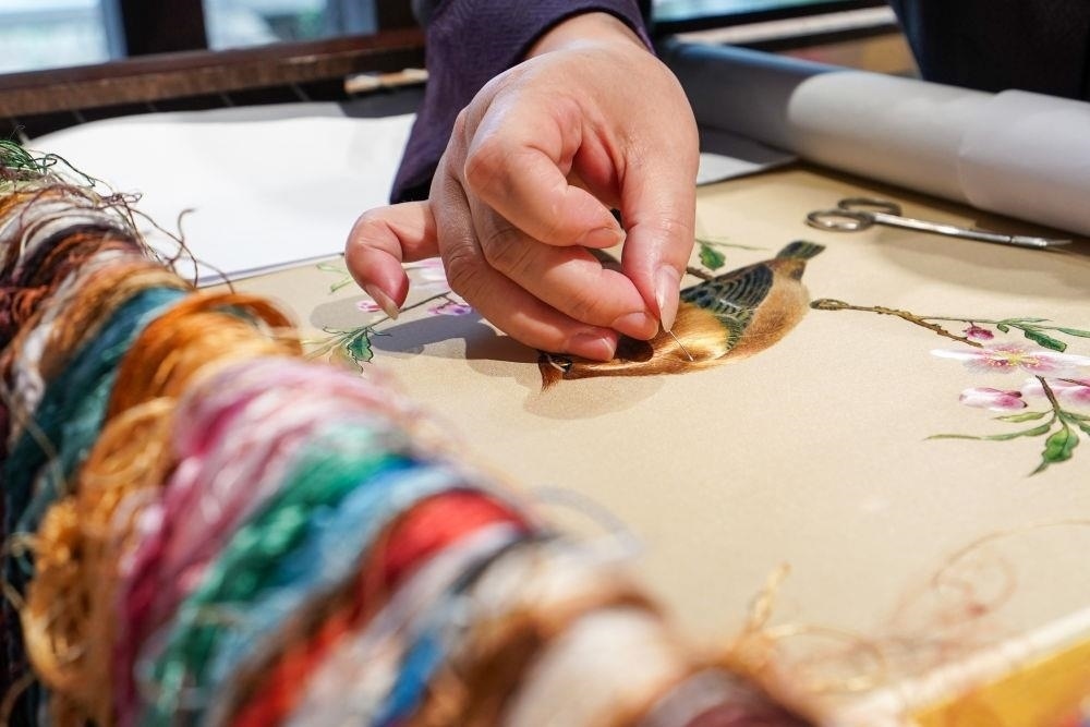 △2023年7月6日，盧建英在江蘇蘇州平江路的工作室內(nèi)刺繡。