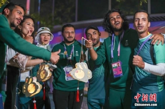 資料圖：9月29日，中國傳統(tǒng)節(jié)日中秋節(jié)，杭州亞運(yùn)會(huì)運(yùn)動(dòng)員村舉辦中秋主題活動(dòng)，中外運(yùn)動(dòng)員們歡聚一堂。圖為沙特阿拉伯運(yùn)動(dòng)員手持燈籠拍攝照片。<a target='_blank' href='/'><p align=