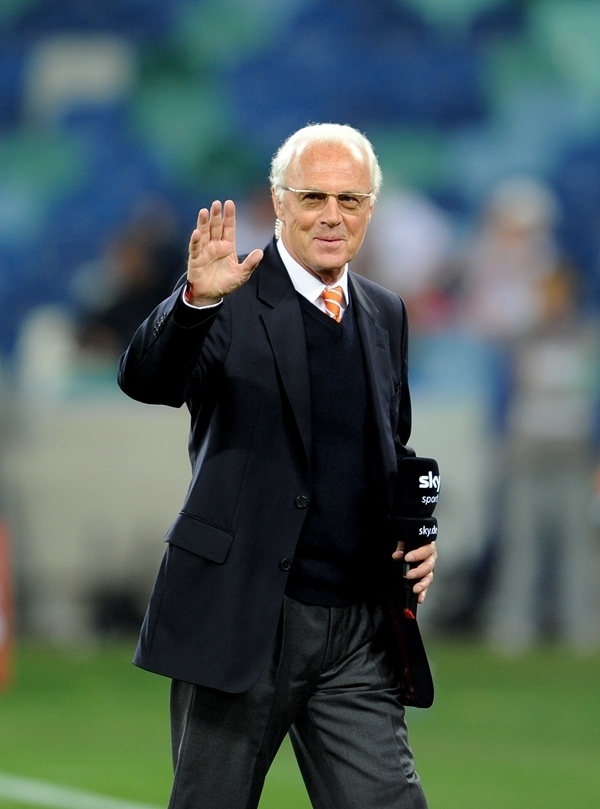 這是2010年7月7日，在南非德班舉行的2010年足球世界杯德國隊(duì)對陣西班牙隊(duì)的半決賽前，貝肯鮑爾接受電視臺(tái)采訪時(shí)和友人打招呼。新華社記者 王毓國 攝