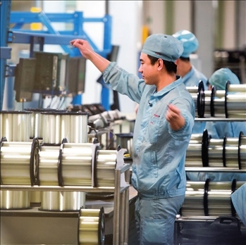 在位于武漢的長飛光纖光纜股份有限公司光纖生產(chǎn)車間內(nèi)，工作人員對光纖進行檢測（資料圖片）。肖藝九攝/本刊