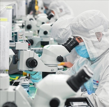 在位于武漢中國光谷的光電器件研發(fā)制造商——武漢光迅科技股份有限公司生產(chǎn)車間內(nèi)，技術人員在光模塊生產(chǎn)線作業(yè)（2023年4月11日攝）。程敏攝/本刊