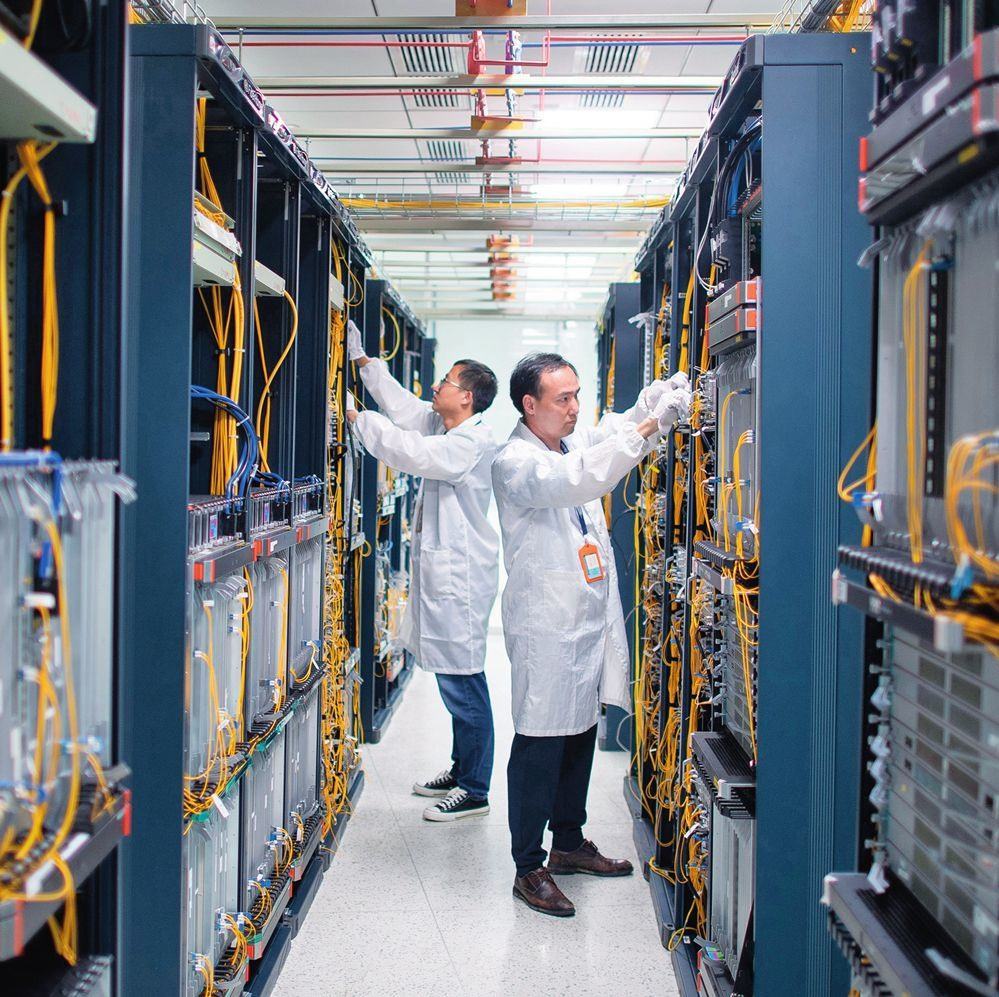 在位于武漢中國光谷的光電器件研發(fā)制造商——武漢光迅科技股份有限公司生產(chǎn)車間內(nèi)，技術人員在光模塊生產(chǎn)線作業(yè)（2023年4月11日攝）。程敏攝/本刊