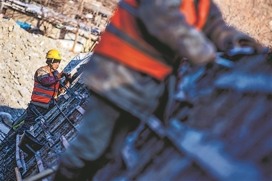 1月3日，房山區(qū)，工人正在雙泉河修筑堤壩。