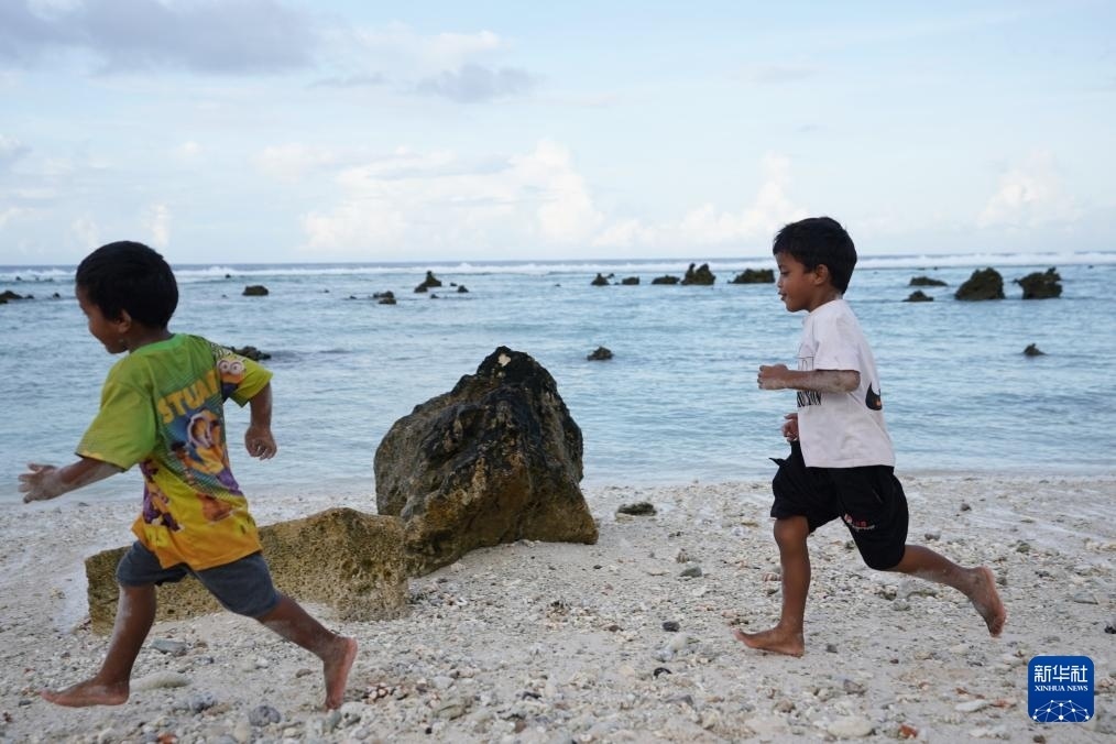 1月20日，兒童在瑙魯海邊嬉戲。新華社記者 王申 攝