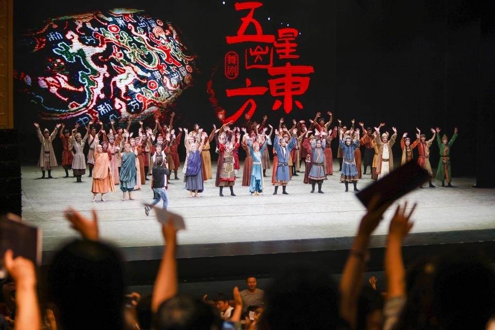 2023年7月31日，新疆和田地區(qū)新玉歌舞團在烏魯木齊京劇院演出舞劇《五星出東方》后和觀眾互相揮手致意。這場演出是第六屆中國新疆國際民族舞蹈節(jié)的參演劇目之一，曾榮獲國家“文華獎”等。新華社記者 郝昭 攝