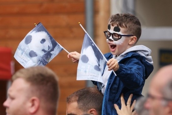  2023年7月26日，在法國(guó)圣艾尼昂市博瓦勒野生動(dòng)物園外，一名兒童等待送別熊貓“圓夢(mèng)”。新華社記者 高靜 攝
