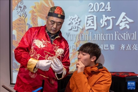 1月28日，在上海豫園舉行的民俗活動上，美國馬斯卡廷中學(xué)學(xué)生在非遺傳承人的指導(dǎo)下吹糖偶。 新華社記者 王翔 攝