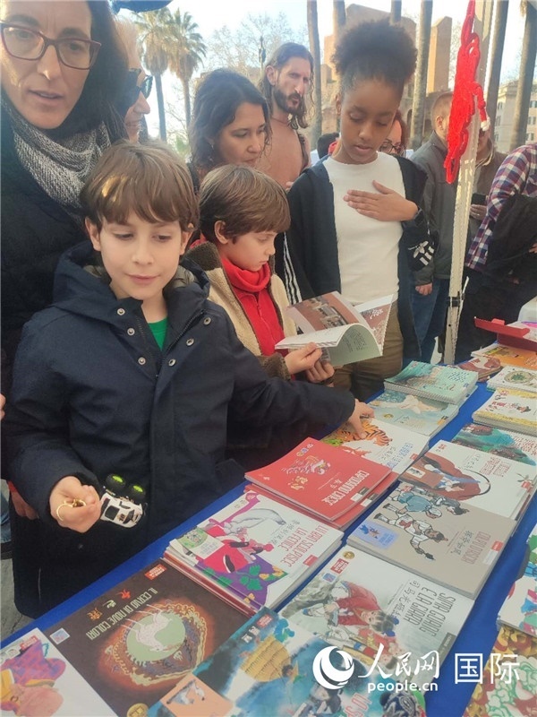 印刷精美的中國傳統(tǒng)文化叢書吸引了小游客的注意。人民網(wǎng)記者鄭彬攝