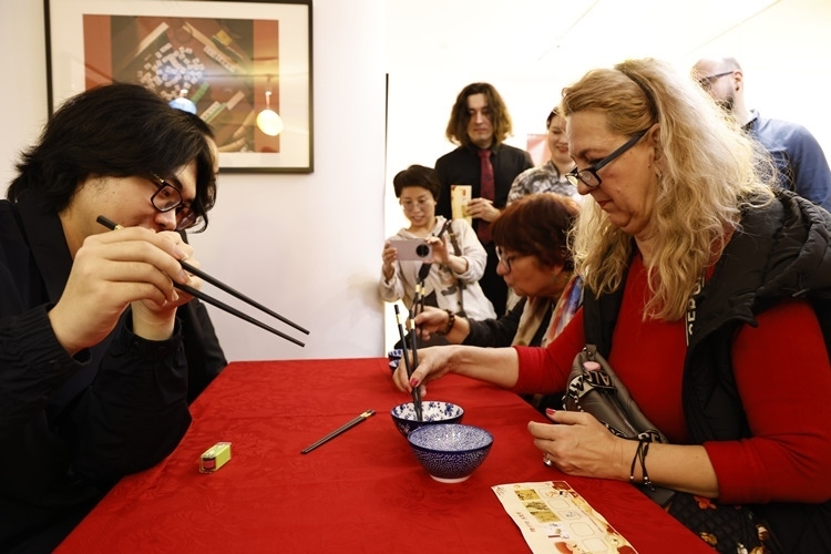 羅馬尼亞觀眾體驗用筷子夾花生。中國文化中心供圖