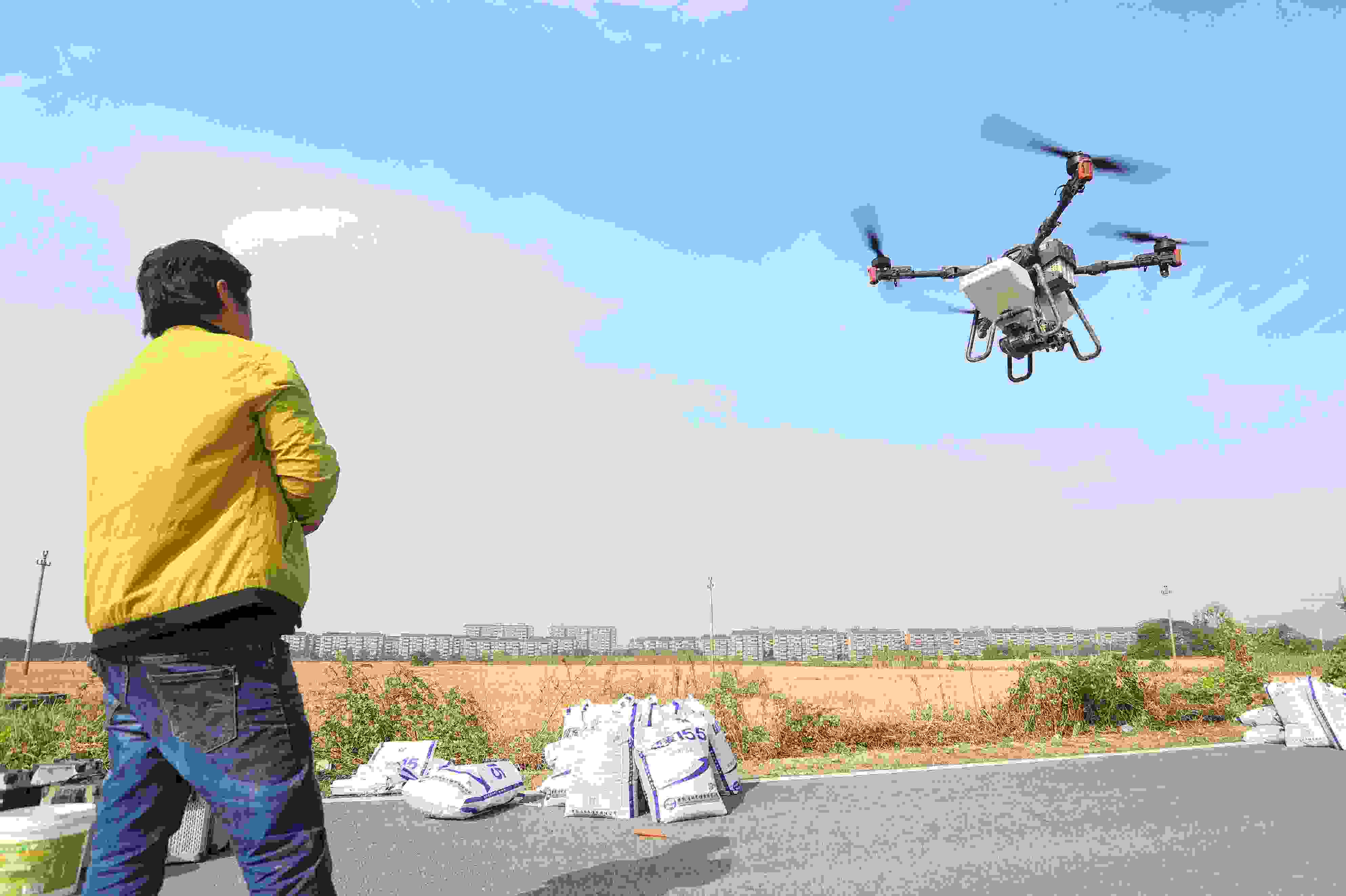 2023年11月15日，浙江嘉興，南湖區(qū)七星街道一處農(nóng)田里，農(nóng)民操縱無人機進行冬小麥飛播。