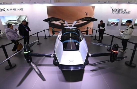 2023年12月1日，在鏈博會智能汽車鏈展區(qū)小鵬汽車展臺，參觀者觀看一臺智能飛行器。新華社記者蔡湘鑫攝