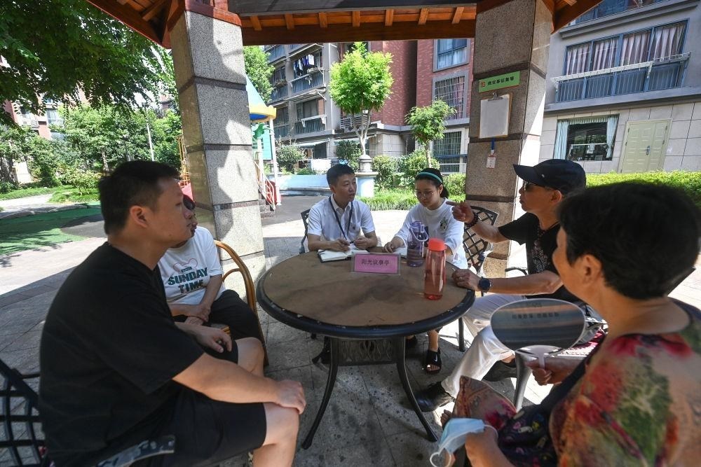 △2023年7月21日，在位于浙江杭州臨安區(qū)錦南街道水岸陽光小區(qū)的陽光議事廳，街道干部在聽取居民們反映的問題及意見。