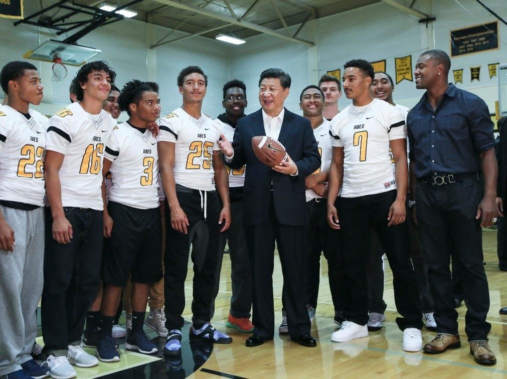 2015年9月23日，國家主席習(xí)近平參觀美國塔科馬市林肯中學(xué)。這是習(xí)近平在學(xué)校體育館，同上橄欖球訓(xùn)練課的學(xué)生們親切交談。新華社記者 蘭紅光 攝